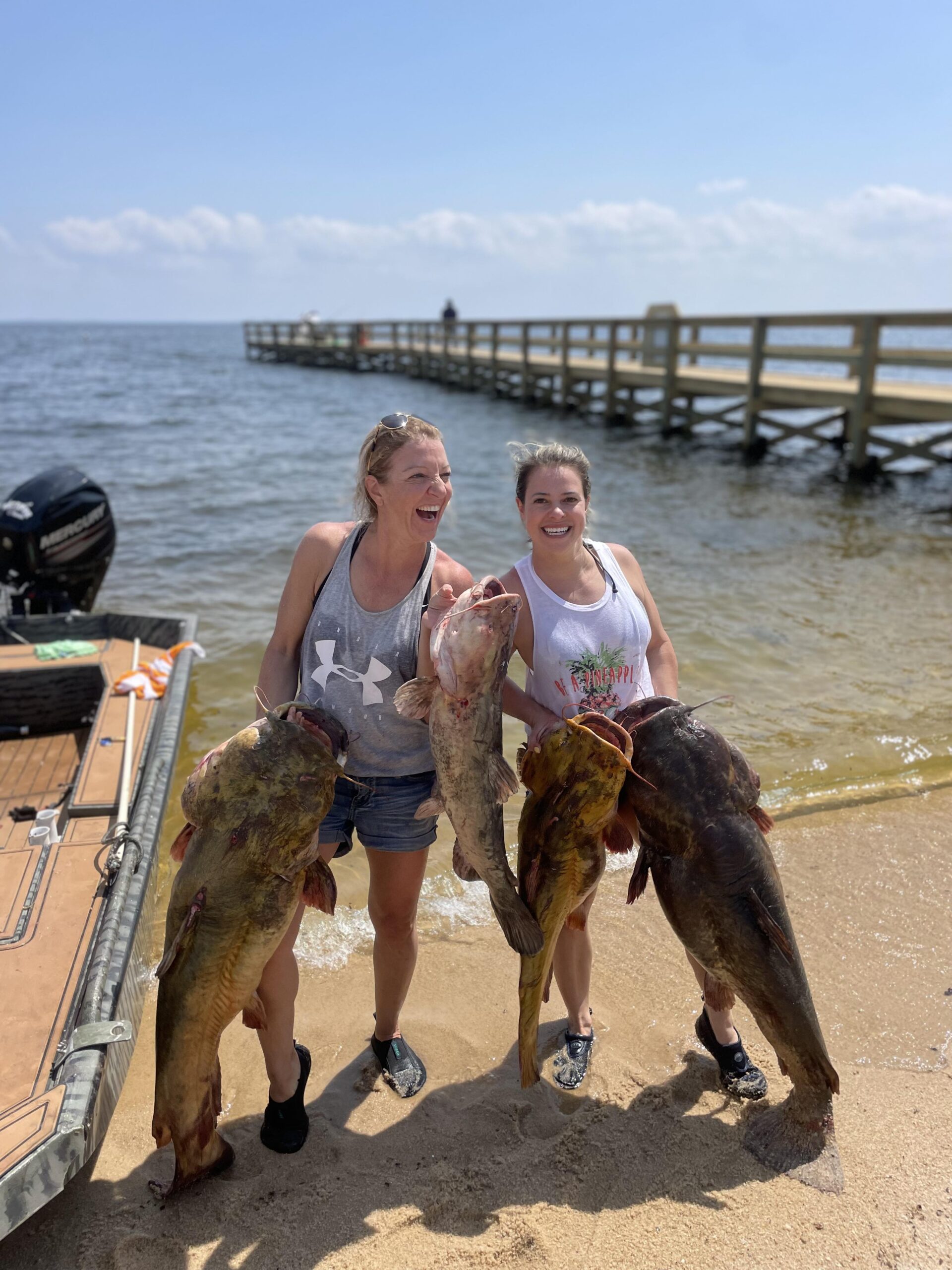 Two women shown with catfish after noodling trip in South Carolina.